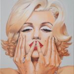 Marilyn Monroe mit beiden Händen im Gesicht und schmalen Augen